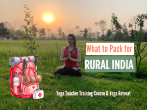 Woman practicing yoga at sunrise in rural India, sitting on grass with fields and trees, next to illustrated backpack, representing what to pack for rural India for yoga retreat or yoga teacher training.