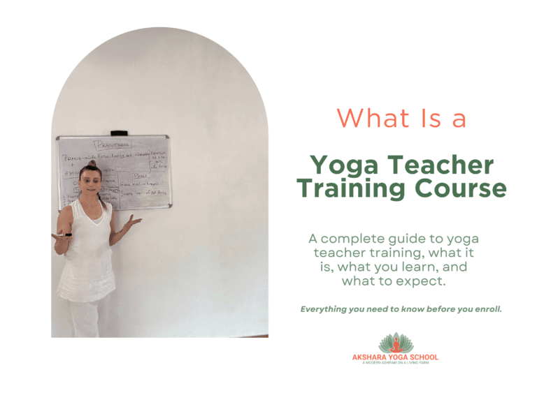 Yoga teacher Varvara teaching a pranayama theory class at Akshara Yoga School, rural India, with notes on a whiteboard for yoga teacher training course
